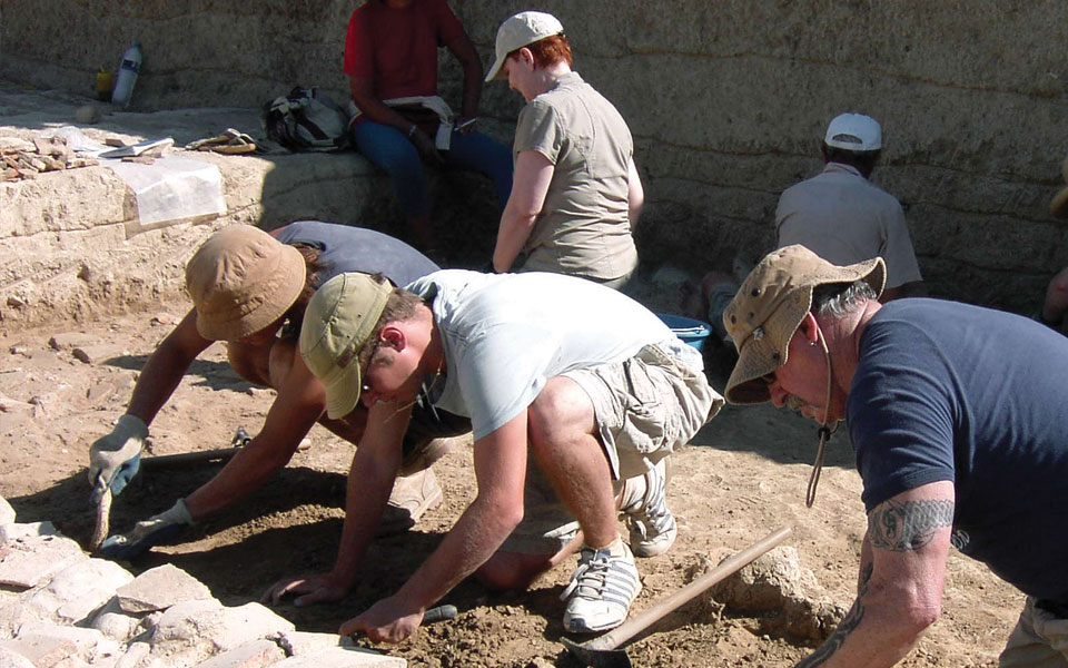 Greek and roman studies student group working together at a dig site